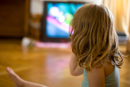 Jovem assistindo televisão | Sheknows.com