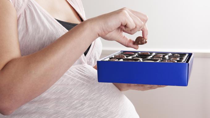 Kobieta je czekoladki w ciąży