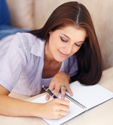 Kobieta pisze w swoim dzienniku