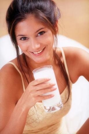 Женщина пьет молоко в пижаме
