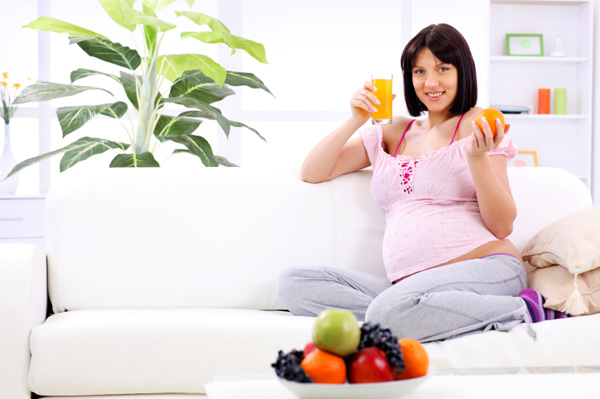 Zwangere vrouw die sinaasappels eet