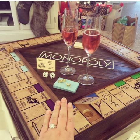 Mann macht seiner Freundin einen Heiratsantrag mit einem Monopoly-Brett