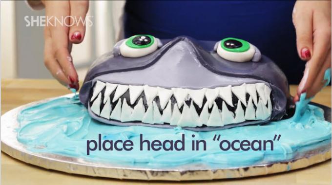 Așezați tortul cu rechini pe un ocean de glazură albastră