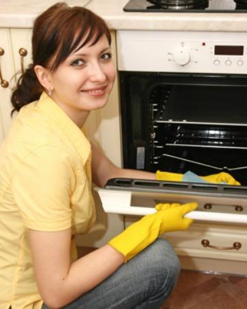 Frau putzt den Ofen