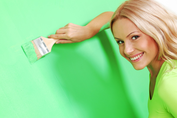 Žena malování zdi zářivé barvy