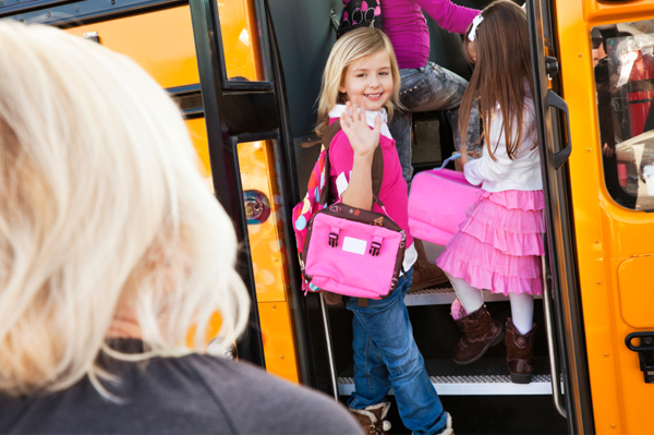 Malá dívka nastupující do školního autobusu