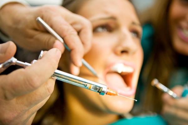 Erschrockene Frau beim Zahnarzt