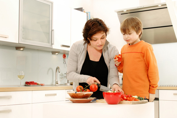 Mamá cortando verduras con su hijo