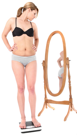 Frau im Bikini mit Blick in den Spiegel