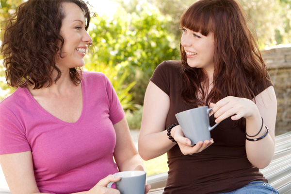 Maman et adolescent discutant autour d'un café