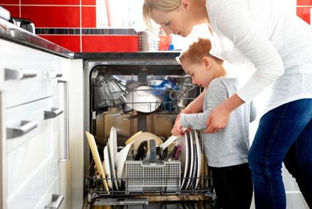 Māte un dēls ielādēja trauku mazgājamo mašīnu