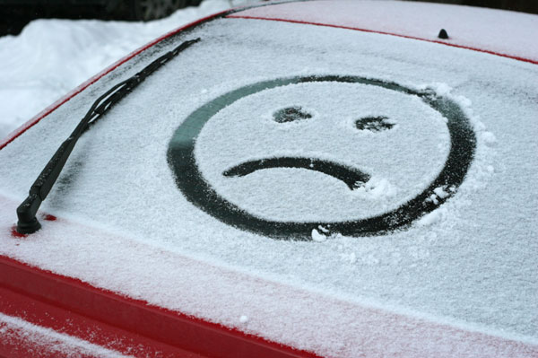 बर्फ में कार की खिड़की पर उदास चेहरा